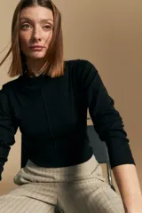 Polera de manga larga color marrón claro, con cuello alto y costura vertical decorativa en el frente.