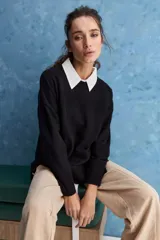 Sweater blanco de punto con diseño holgado, cuello redondo, mangas largas acampanadas y detalles de textura horizontal en el tejido.