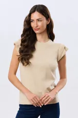 Remera tejida de algodón en color beige, de cuello redondo, sin mangas y con detalles de volados estructurados en los hombros.