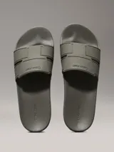 Ojotas tipo slide de color verde oliva, con doble tira superior de TPU con relieve y logotipo grabado. Cuentan con plantilla moldeada ergonómica con soporte para el arco plantar y suela de EVA.