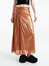 Falda larga plisada color cobre metalizado, con detalle drapeado en la cintura.