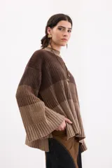 Sweater de punto con diseño de franjas horizontales en degradé de tonos marrones. Presenta cuello redondo a la base, corte recto relajado y mangas largas amplias con tajos laterales.