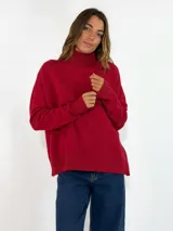 Sweater de punto color rojo, con cuello alto, manga larga y diseño holgado con terminaciones acanaladas en puños y ruedo.