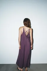 Vestido midi color lila de cuello halter y tirantes finos ajustables en la espalda.