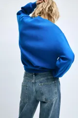Jersey de punto color azul, con cuello redondo, manga larga y detalles de rib en cuello, puños y dobladillo.