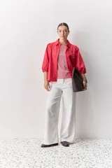 Camisa blanca de algodón, de calce relajado, con cuello camisero, frente abotonado y mangas largas abullonadas.