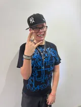 Remera negra de corte regular con estampado frontal de gran tamaño en serigrafía color azul, con diseño de caligrafía abstracta. Cuenta con cuello reforzado y grifa de la marca en la manga.
