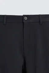 Pantalón chino de corte slim fit, confeccionado en tejido elástico. Presenta bolsillos frontales, bolsillos traseros de vivo con botón y cierre frontal con cremallera y botón.