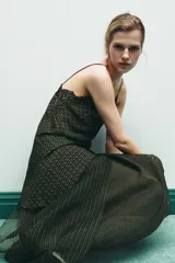 Top estampado con diseño geométrico en tonos verdes y marrones, confeccionado en viscosa 100%. Presenta escote en pico, tirantes finos y detalle de encaje negro a contraste. El bajo tiene un acabado asimétrico.