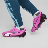 Championes de fútbol Puma Ultra Ultimate FG/AG, de color rosado con detalles en blanco y negro, diseñados con tecnología ULTRAWEAVE para mayor velocidad y ligereza.