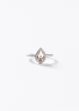Anillo de plata 925 con una zirconia central en forma de gota color champagne, rodeada de pequeñas zirconias y pavé en el aro.