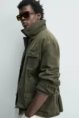 Cazadora relaxed fit de algodón color verde militar, con efecto lavado, cuello solapa de pana a tono y manga larga. Cuenta con bolsillos de plastrón delanteros y cierre frontal de botonadura.