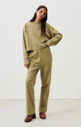 Pantalon deportivo de corte recto y tiro alto, confeccionado en tejido de algodón en color verde oliva. Presenta cintura elástica y un pequeño logo bordado en el lateral.