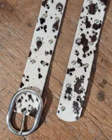 Cinto de cuero marrón con hebilla metálica de estilo envejecido y detalle de tachas metálicas en diferentes tonos en el extremo.