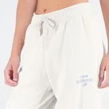 Pantalón de jogging color crema, con cintura elástica ajustable con cordón, bolsillos laterales y logo de New Balance estampado en la pierna izquierda.