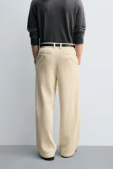 Pantalón de corte wide fit confeccionado en pana de algodón color marrón oscuro. Presenta bolsillos frontales, bolsillos traseros de vivo con botón y cierre frontal con cremallera y botón.