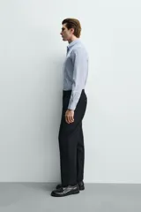 Camisa regular fit de algodón con diseño de rayas finas celestes y blancas. Cuenta con cuello abotonado, manga larga con puños abotonados y cierre frontal de botones.