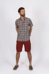 Camisa de manga corta con estampado de cuadros en tonos azul, rojo y beige, confeccionada en algodón. Presenta cuello clásico y cierre frontal con botones.