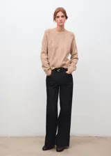 Sweater de punto color tostado, de cuello redondo y mangas largas con diseño texturizado de ochos y detalles calados.
