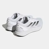 Championes de running Adidas Duramo RC, color blanco con las tres franjas laterales en gris metalizado. Presentan una capellada de malla transpirable y una suela gruesa de EVA blanca con detalles en negro en la parte inferior.