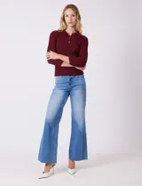 Buzo de tejido acanalado marca Rio & Rian, color beige, con cuello tipo polo con solapa y botones frontales, y mangas tres cuartos.