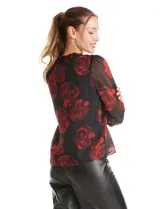 Blusa de gasa con estampado floral en tonos rojos sobre fondo negro. Presenta escote en V, mangas largas traslúcidas con puños ajustados y detalles de fruncido en los hombros.