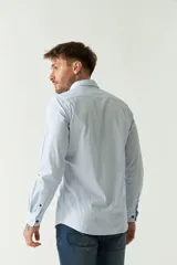 Camisa de hombre de corte slim fit, confeccionada en algodón con diseño de rayas verticales finas en tonos claros. Presenta cuello clásico, cierre frontal con botones y logo bordado en el pecho.