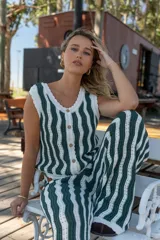 Chaleco tejido sin mangas con rayas verticales verdes y blancas, escote en V y cierre frontal con botones.