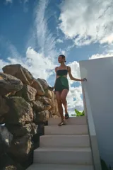 Minivestido negro de lino y rayón con escote recto, breteles regulables y espalda con tiras regulables.