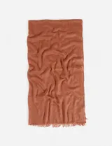 Pashmina rectangular color ladrillo, confeccionada en algodón liso con terminaciones desflecadas.