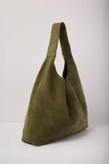Cartera tipo tote de gran capacidad, confeccionada en cuero agamuzado color verde seco. Presenta un diseño de cuerpo holgado con costuras verticales y un asa única ancha integrada para llevar al hombro.