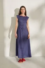 Vestido largo azul marino sin mangas, con escote bote y botonadura frontal completa con botones a contratono. Presenta costuras verticales visibles.