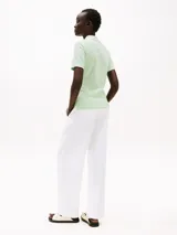 Chomba verde claro de piqué de algodón orgánico elástico, corte slim, cuello de chomba y cartera de cuatro botones.