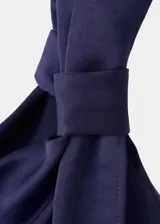 Vestido midi asimétrico de un solo hombro, color azul marino, confeccionado en satén con fruncido lateral, tajo discreto en el lateral de la falda y diseño entallado.