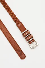 Cinturón de cuero vacuno trenzado en color negro, con hebilla metálica plateada de diseño rectangular con detalles de tachas.