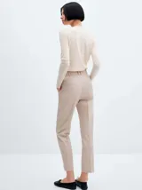 Pantalon de vestir color beige, de corte recto y entallado, con detalle de pinzas frontales y cierre de cremallera con botón oculto.