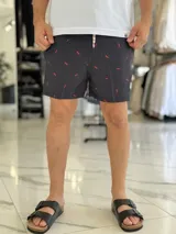 Short de baño negro con pequeño estampado rojo repetido y cordón ajustable en la cintura.