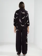 Pantalón palazzo negro con estampado de sirenas en color beige.