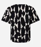 Blusa de manga corta con escote en V y un estampado geométrico abstracto en blanco y negro.