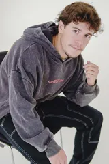 Canguro negro con capucha y bolsillo delantero tipo canguro. Estampa frontal con la frase "Wear More & Worry Less" en color rosa.