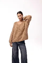 Sweater de punto de textura liviana con escote amplio y mangas largas levemente abullonadas. Presenta un calce relajado y holgado.