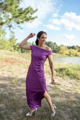 Vestido midi color violeta con textura brillante, escote off-shoulder y mangas cortas.