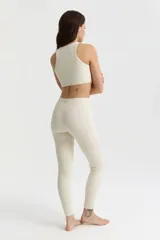 Calza larga de tiro alto, confeccionada en tejido técnico elástico que ofrece sujeción y moldea la figura.