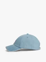 Gorra de béisbol Tommy Jeans de estilo vintage, confeccionada en tejido denim de algodón con efecto desteñido en los bordes y costuras. Cuenta con diseño de seis paneles, ojales de ventilación, visera curva con costuras texturizadas, hebilla de ajuste metálica en la parte trasera y parche con el logo de la marca en el frente.