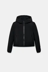 Anorak corto de color negro con acolchado interior, cuello subido con capucha, cierre frontal con cremallera termosellada y bolsillos laterales con cierre. Presenta mangas largas con puños interiores elásticos.