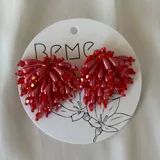 Par de caravanas colgantes con cuentas rojas de diferentes tamaños.