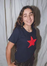 Remera negra de algodón de manga corta con aplique de estrella roja en el pecho.