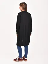 Saco largo negro de punto, con cuello abierto, mangas largas y dos bolsillos delanteros.