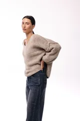 Sweater de tejido de punto con textura liviana, escote en V amplio y mangas largas levemente abullonadas. Presenta un diseño de calce holgado y relajado.