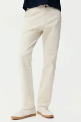 Pantalón chino de sarga elástica de algodón, con cierre de cremallera y botón, bolsillos laterales al bies y bolsillos traseros con botón. Presenta un corte ajustado que define la silueta.
